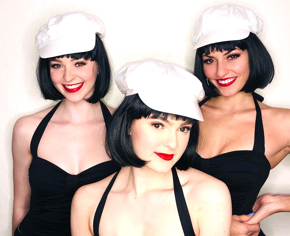 three smiling models in black bobs and white newsboy caps
