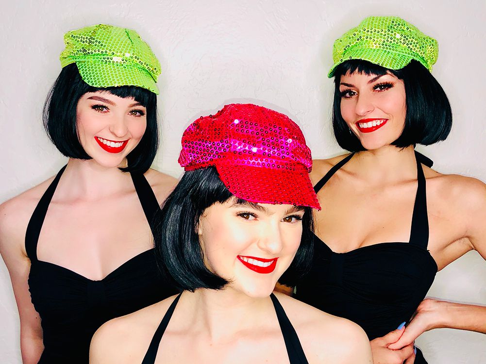 three smiling models in black bobs and green and pink sequined newsboy caps