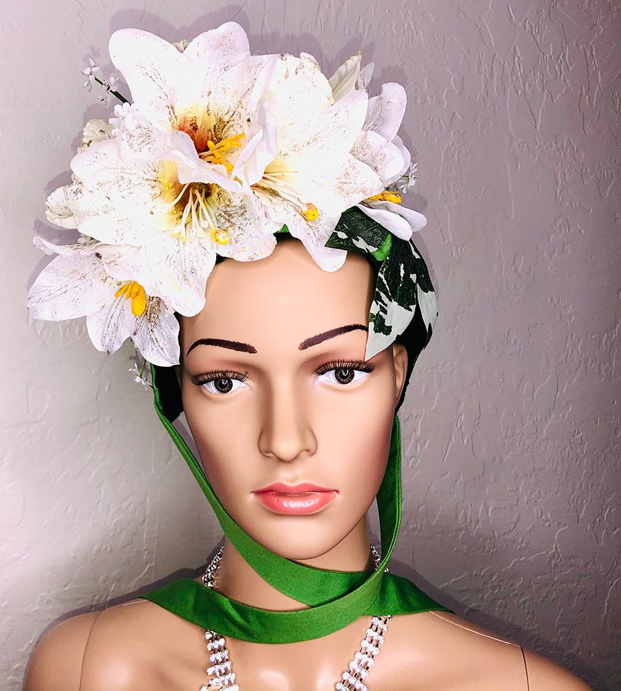 mannequin head in green bonnet with white orchids