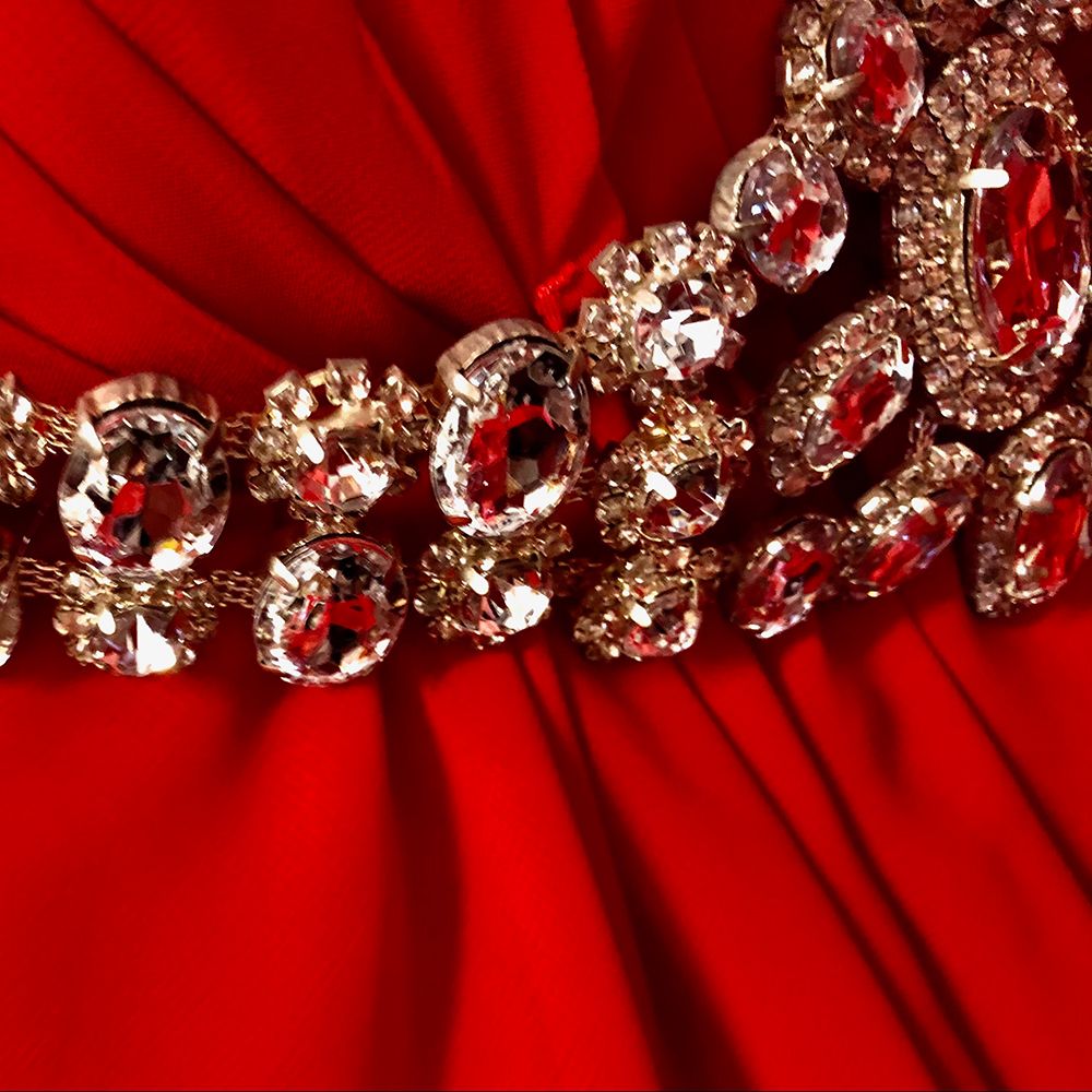 close up of rhinestone belt on red fabric