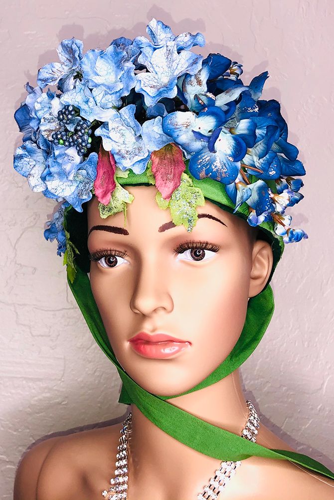 mannequin head in green bonnet with blue hydrangeas