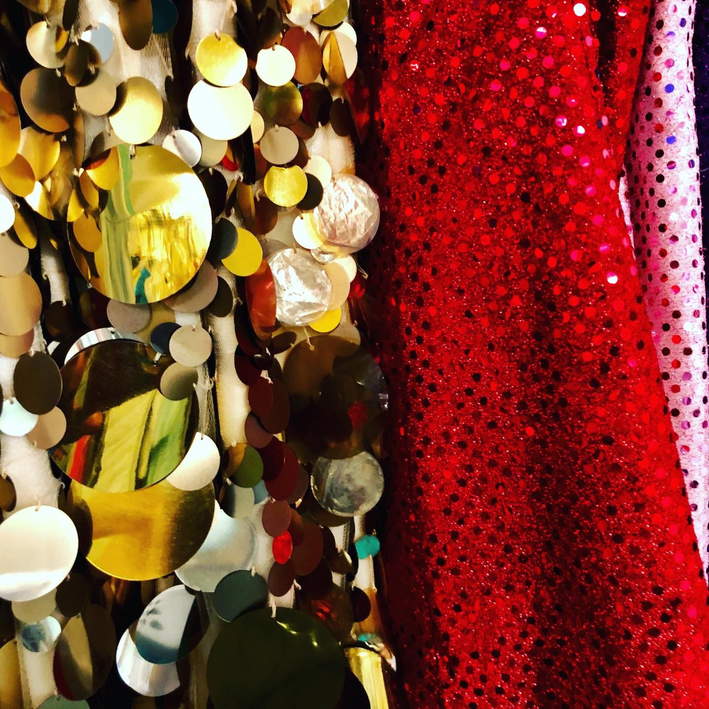 close up of large gold sequins and red fabric with small glittery circles