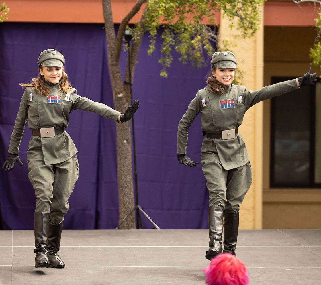 models in olive drab uniforms with jodhpurs, hats, black gloves, and black knee-high boots