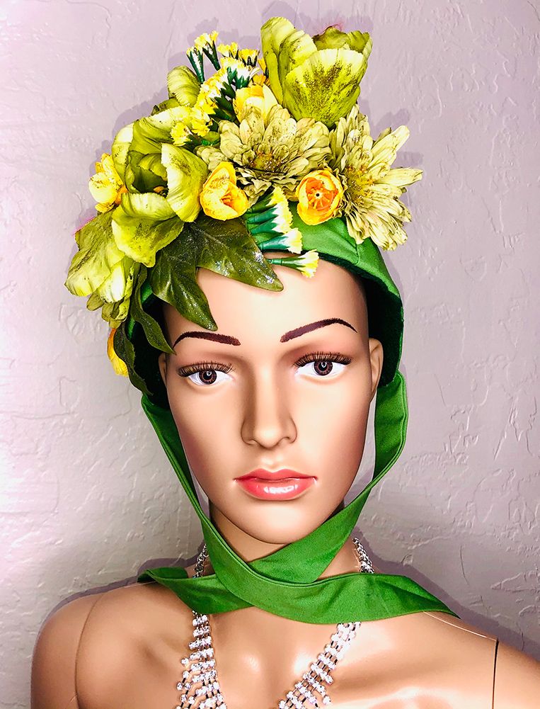 mannequin head in green bonnet with mixed green flowers